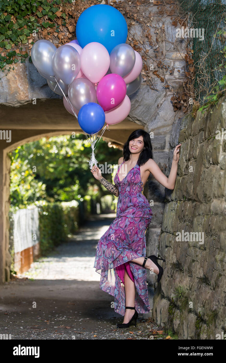 Junge Frau mit langen Kleid posiert mit bunten b Stockfoto