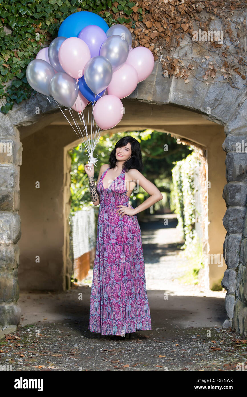 Junge Frau mit langen Kleid posiert mit bunten b Stockfoto