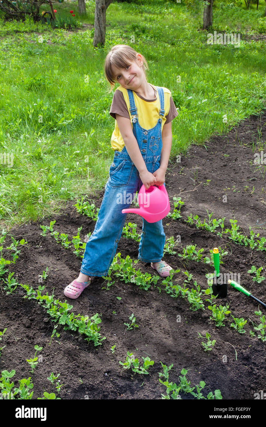 kleines Mädchen im Garten mit Pflanzen Stockfoto