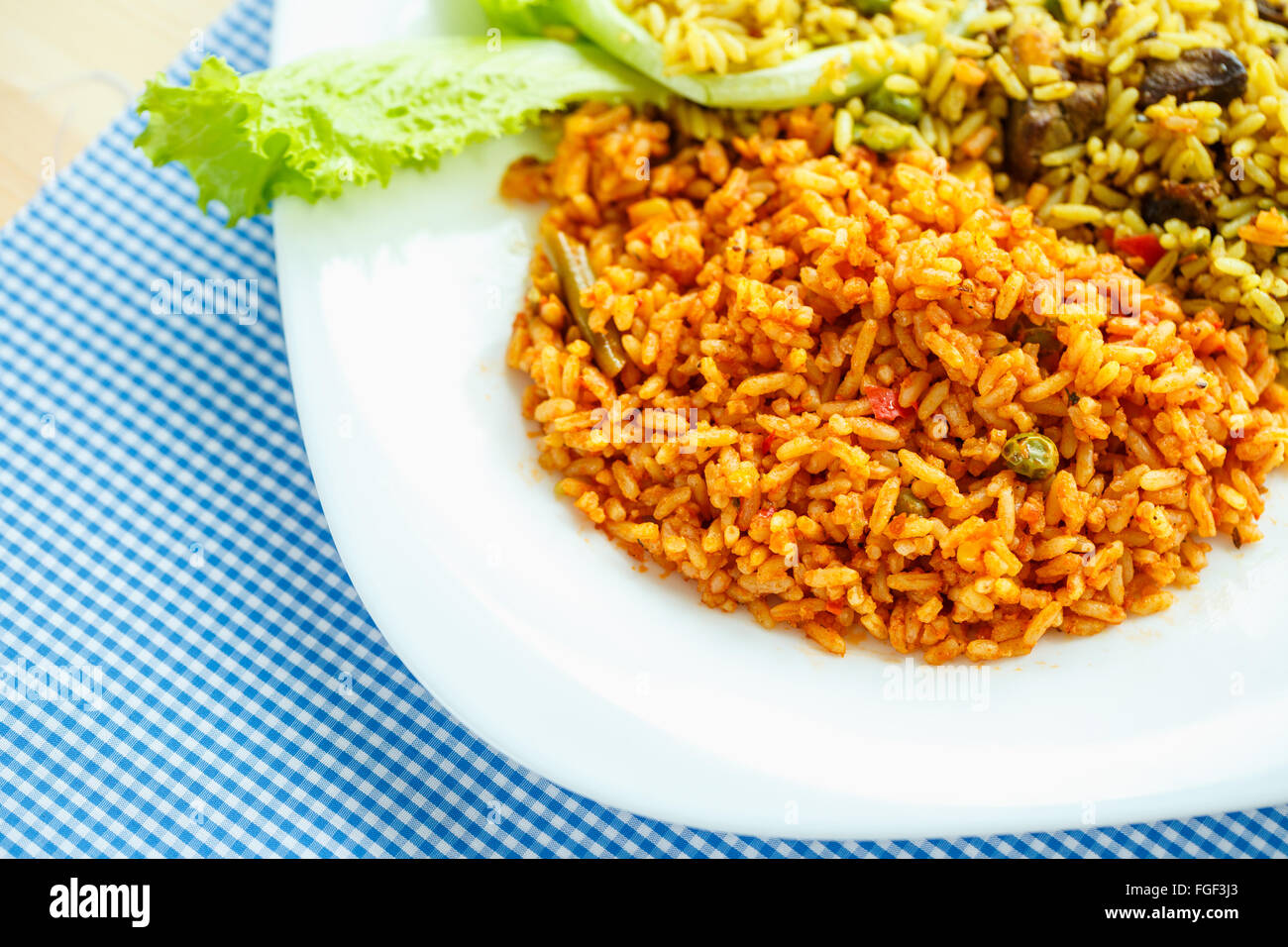 Schmackhaftes Gericht aus zwei Arten von Reis auf einem weißen Teller Stockfoto