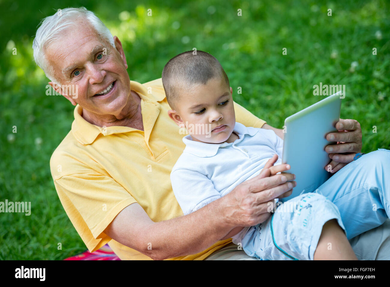 Großvater und Kind im Park mit tablet Stockfoto