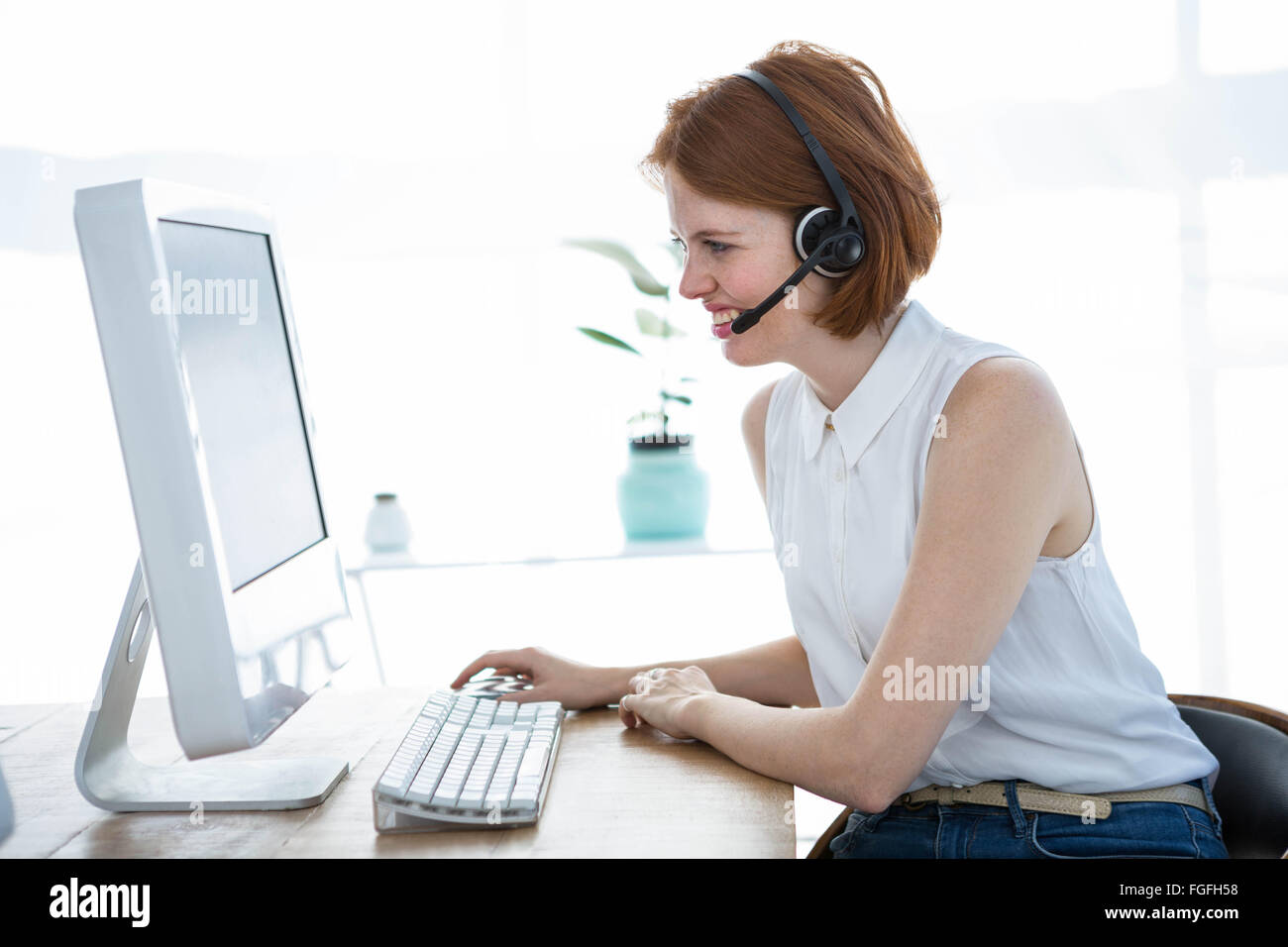 grimassierende Hipster-Business-Frau, die auf ihrem computer Stockfoto