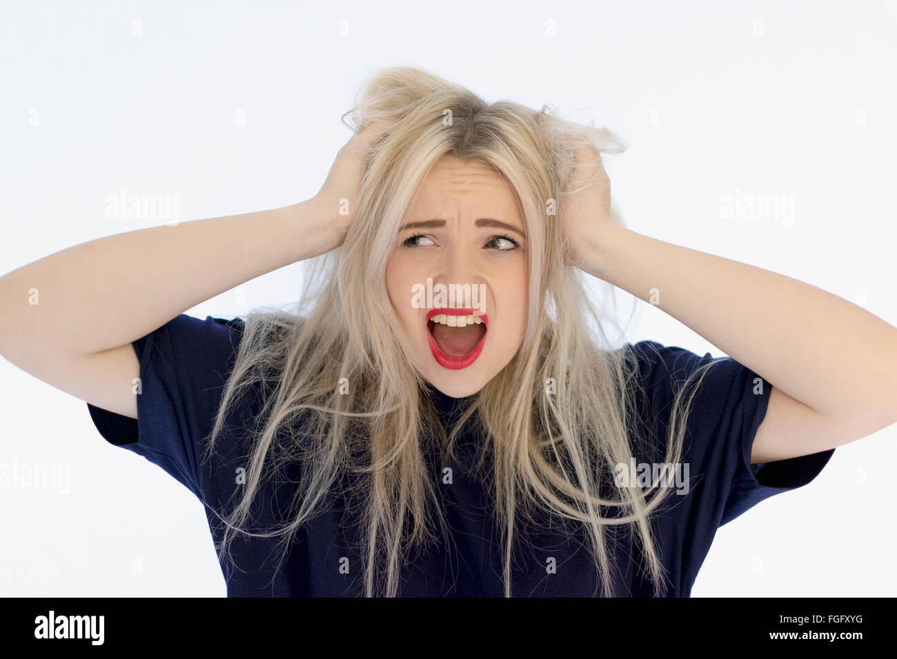 Frau mit ihren Händen in ihr langes blondes Haar mit einem Ausdruck von Stress und frustration Stockfoto