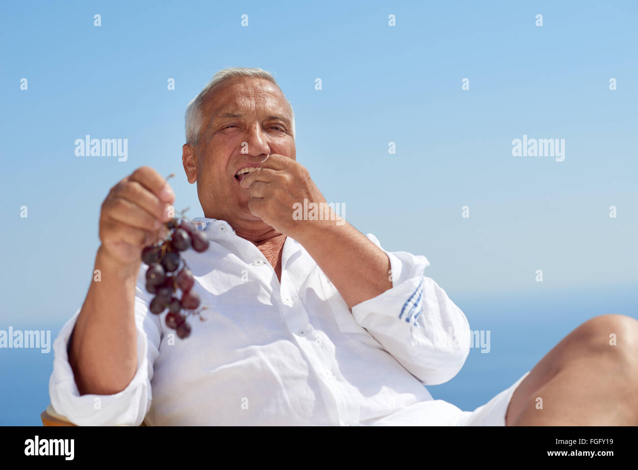 ältere Mann draußen zu sitzen Stockfoto