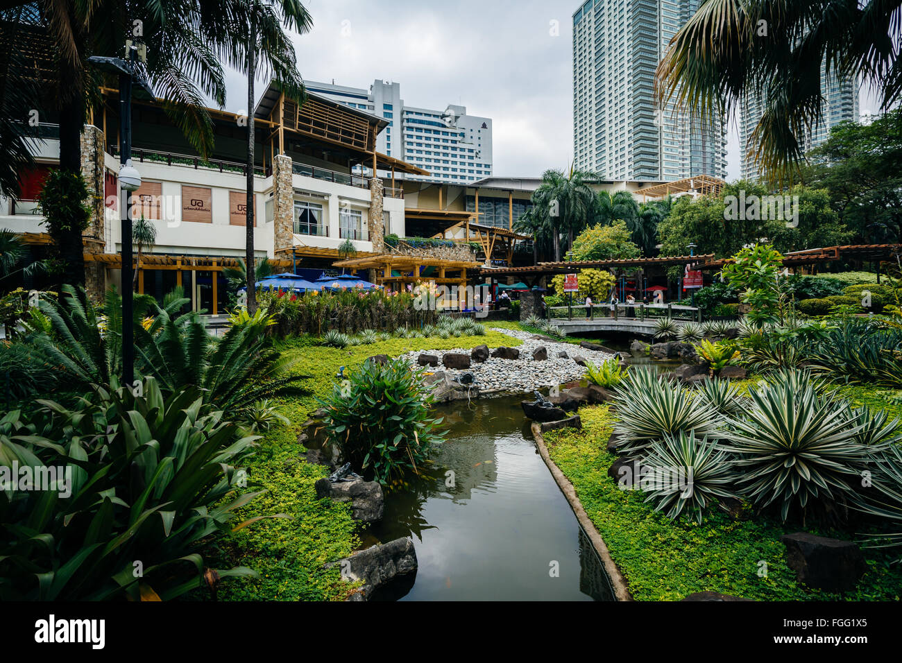 Gärten und Wolkenkratzer im Greenbelt Park in Ayala, Makati, Metro Manila, Philippinen. Stockfoto