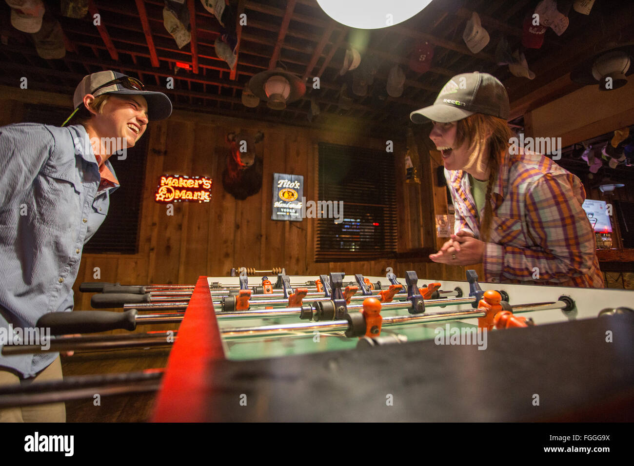 Zwei Frauen lachen und spielen Tischfußball in Montana Bar. Stockfoto