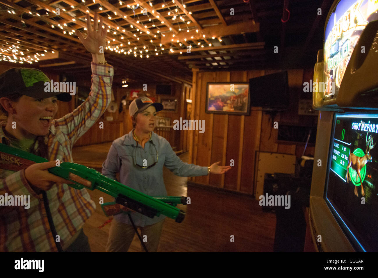 Zwei Frauen lachen und spielen ein Videospiel in Montana Bar. Stockfoto