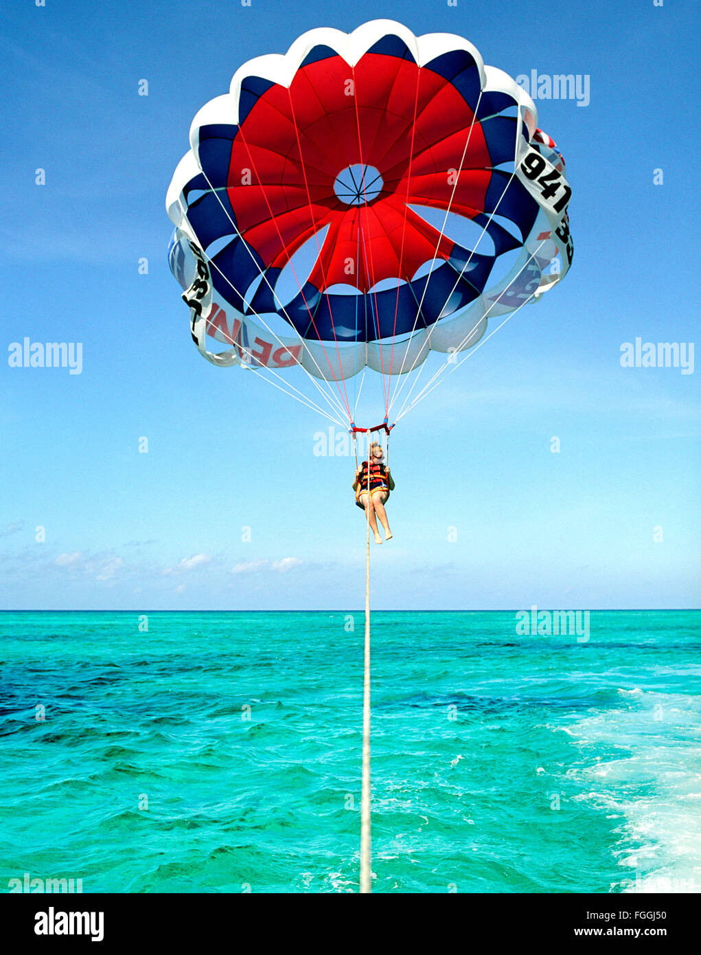 Ein ausländischer Tourist Parasails von Grace Bay Beach, Providenciales, Turks- und Caicosinseln, British West Indies. Stockfoto