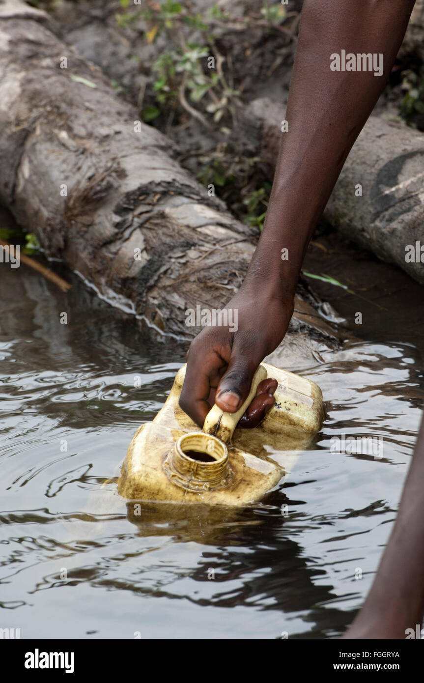 Auffangbehälter Wasser aus einem schmutzigen Blick auf Pool Wasser, Uganda. Stockfoto