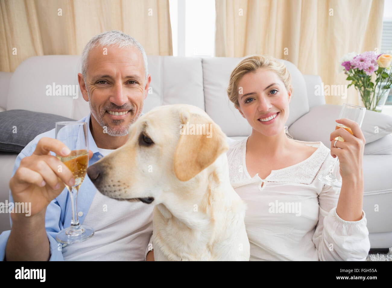 Brautpaar mit ihrem Haustier Hund Champagner trinken Stockfoto