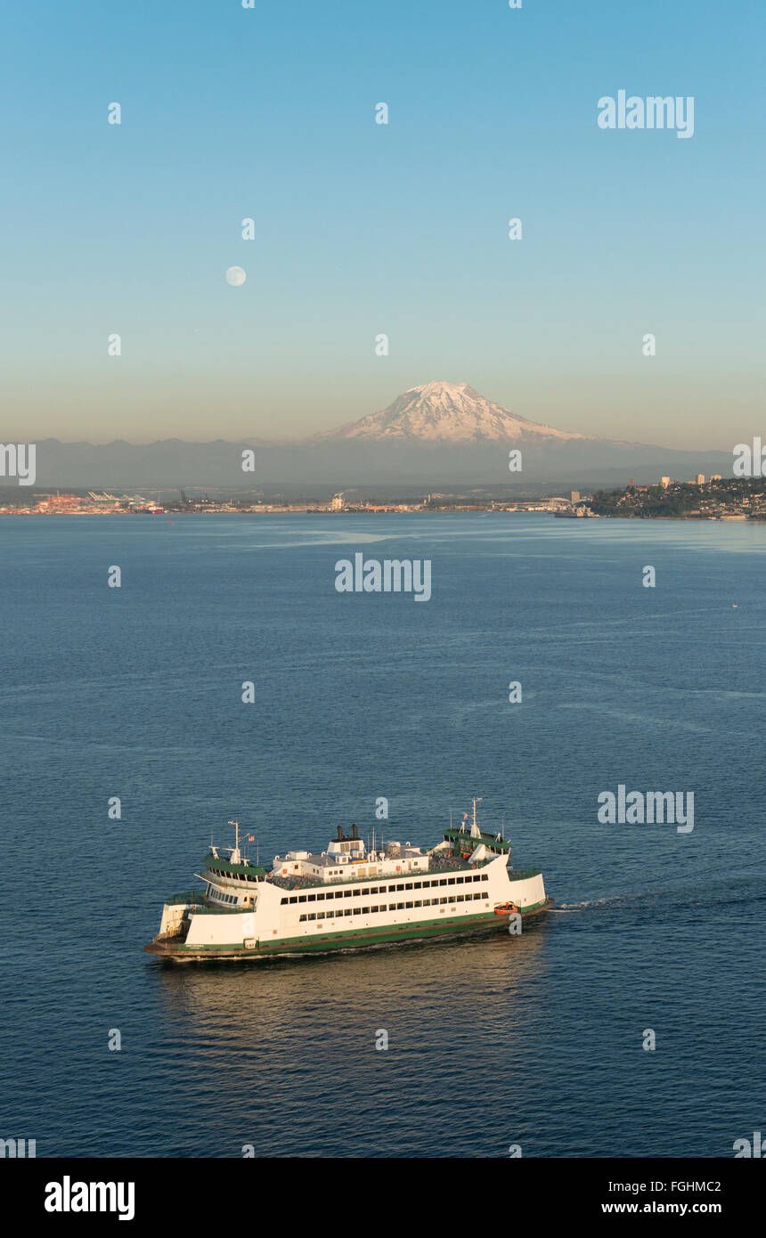 Die Washington State Ferry fährt vor Mount Rainier und Vollmond bei Sonnenuntergang. Stockfoto