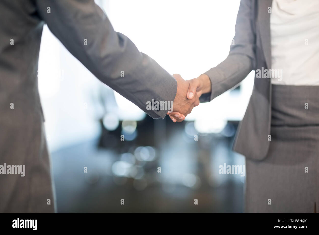 Geschäftsmann Händeschütteln mit Geschäftsfrau Stockfoto