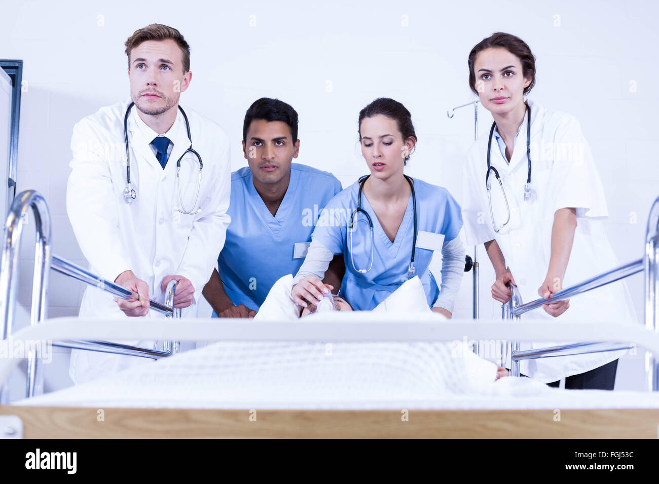 Betroffenen Ärzte stehen in der Nähe von Patienten auf Bett Stockfoto