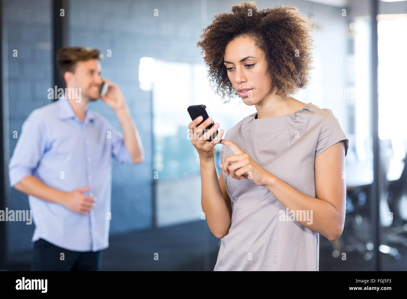 Kolleginnen und Kollegen kommunizieren auf Handy Stockfoto