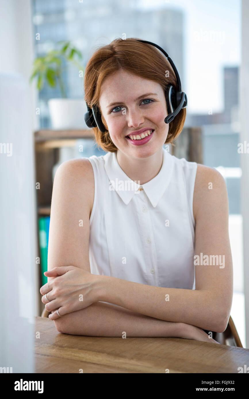 lächelnde Hipster-Business-Frau trägt einen Kopfhörer Stockfoto