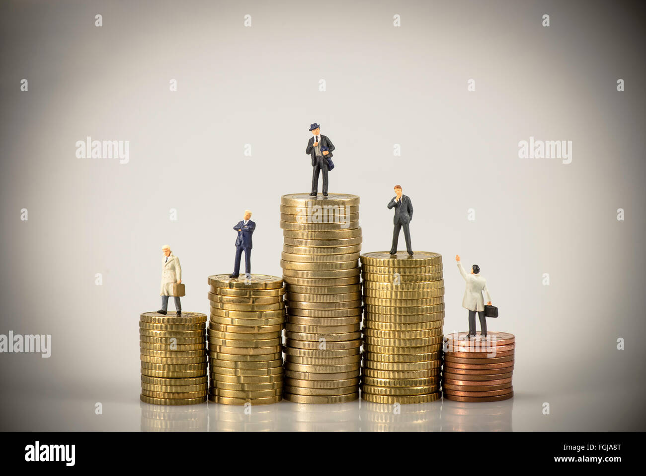 Miniatur-Geschäftsleute auf Haufen von Münzen. Business-Konzept. Makro-Foto Stockfoto