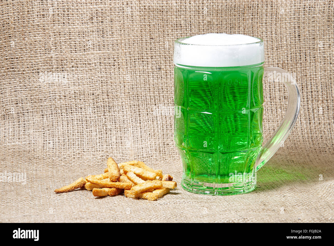 Glas Irish Jungbier und Cracker auf Sackleinen Hintergrund. Traditionelle Symbole der St. Patricks day Stockfoto