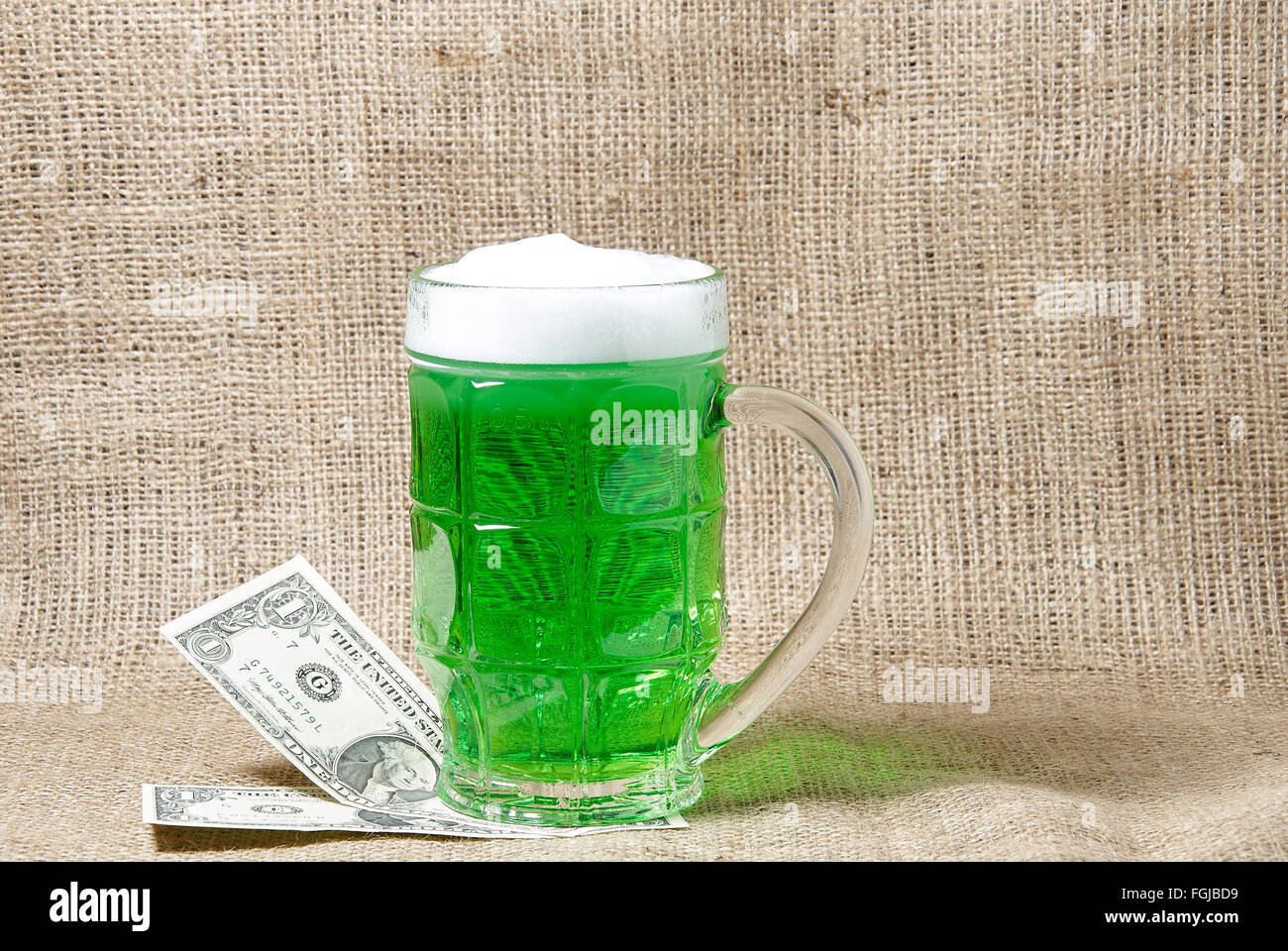 Glas Irish Jungbier und Dollar auf Sackleinen Hintergrund. Traditionelle Symbole der St. Patricks Day. Platz für text Stockfoto