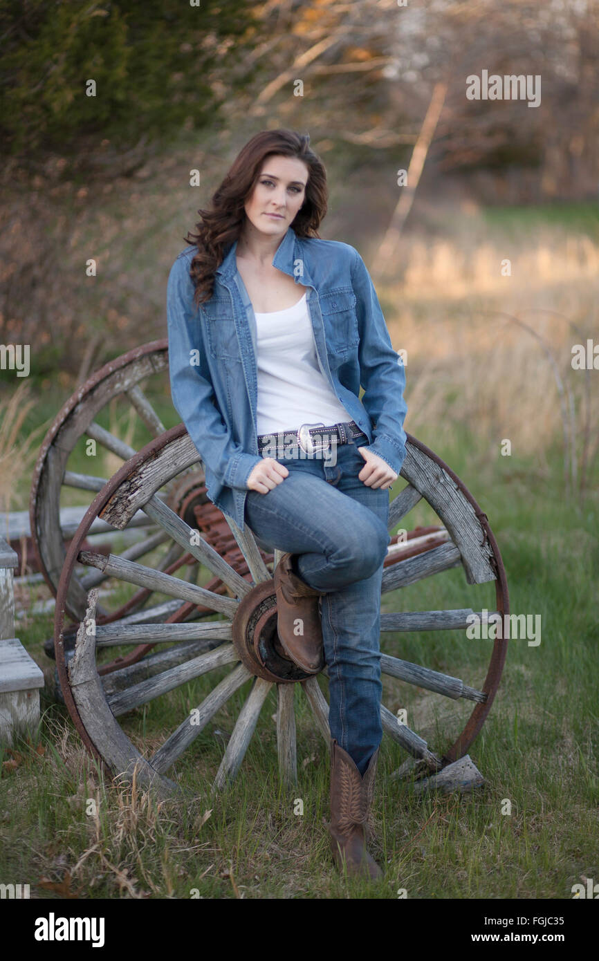 Schöne Brünette Frau in Jeans und Stiefel in ländlicher Umgebung Stockfoto