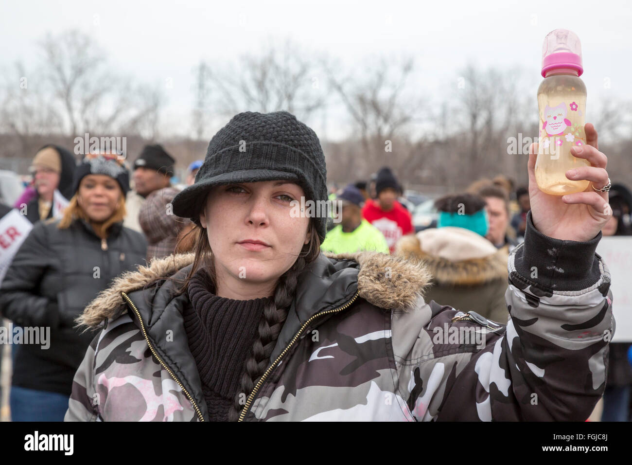 Flint, Michigan USA 19. Februar 2016 - Bewohner marschierten die Flint Wasseraufbereitungsanlage zu verlangen, den Wiederaufbau der Wasser-Infrastruktur der Stadt. Eine Frau trägt eine Flasche Wasser aus dem Wasserhahn Flint. Bildnachweis: Jim West/Alamy Live-Nachrichten Stockfoto