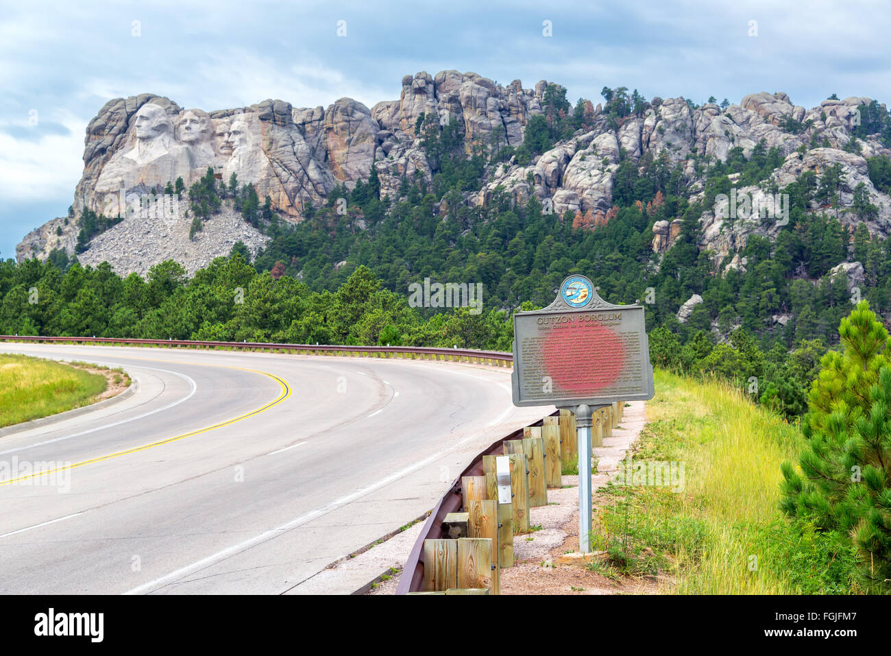 Autobahn, die zum Mount Rushmore mit einem Schild gewidmet Gutzon Borglum im Vordergrund Stockfoto