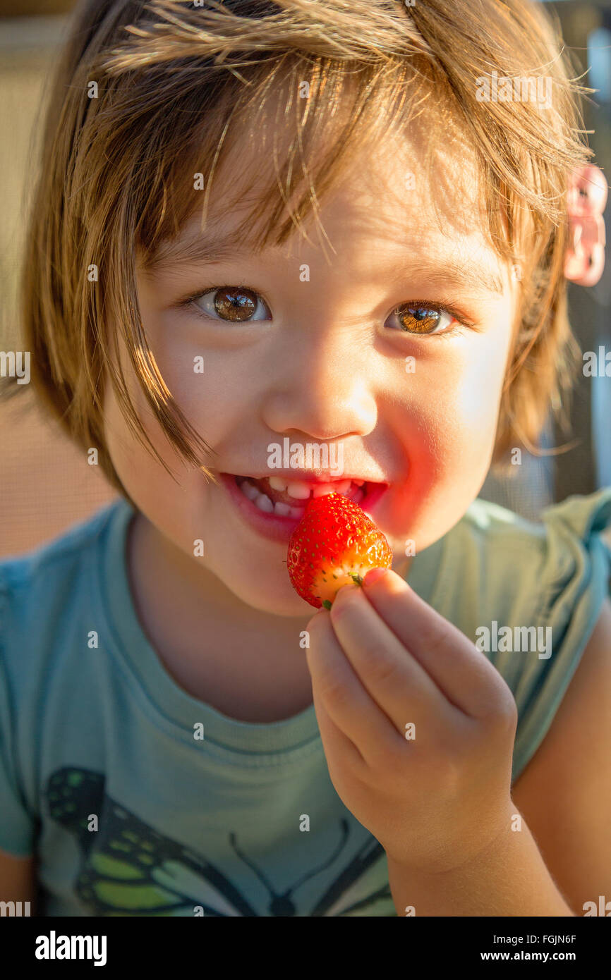 Kleinkind eine Erdbeere essen Stockfoto