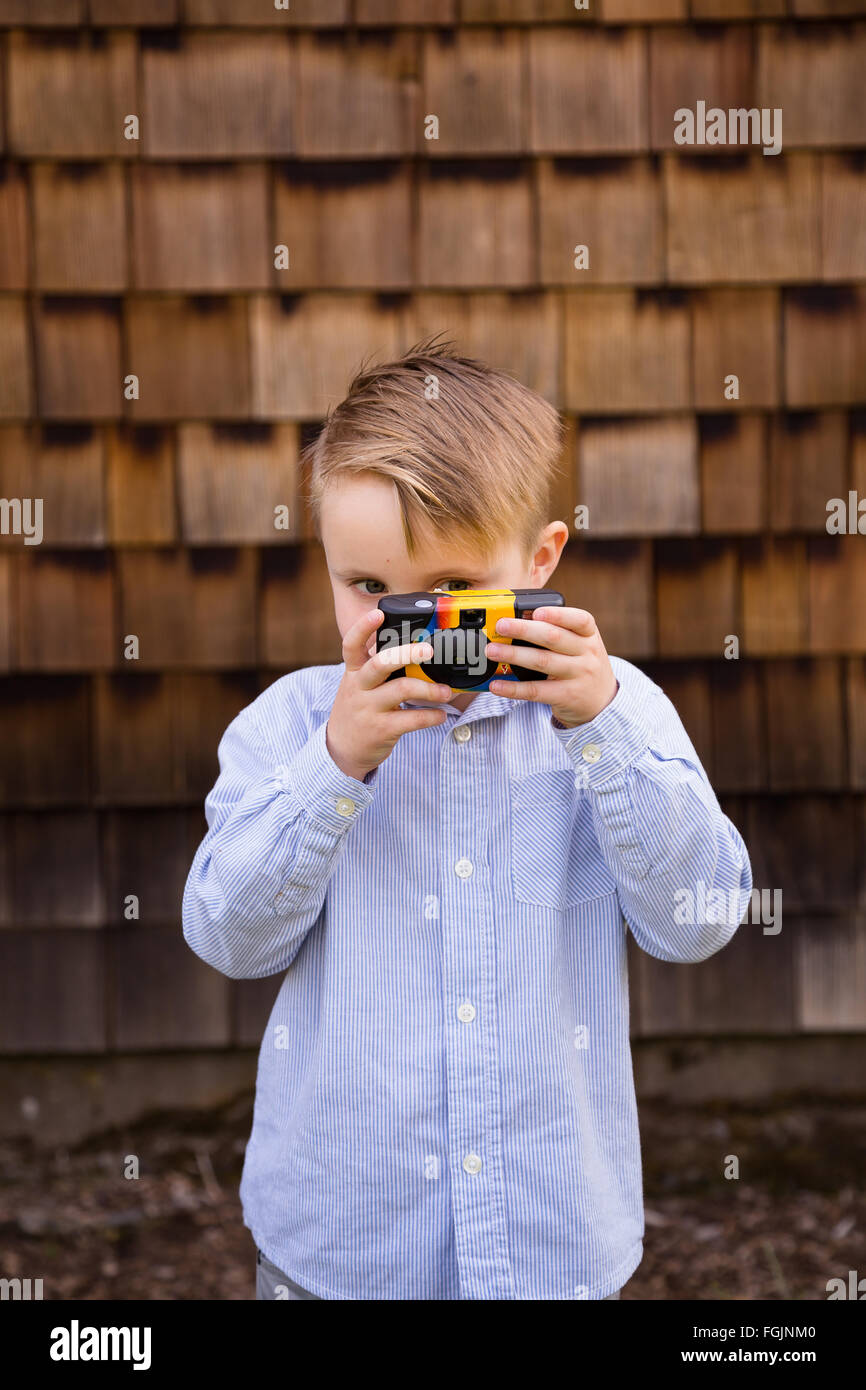 Kleiner Junge mit einer Kamera ist ein zukünftiger Fotograf in diesem Lebensstil-Porträt. Stockfoto