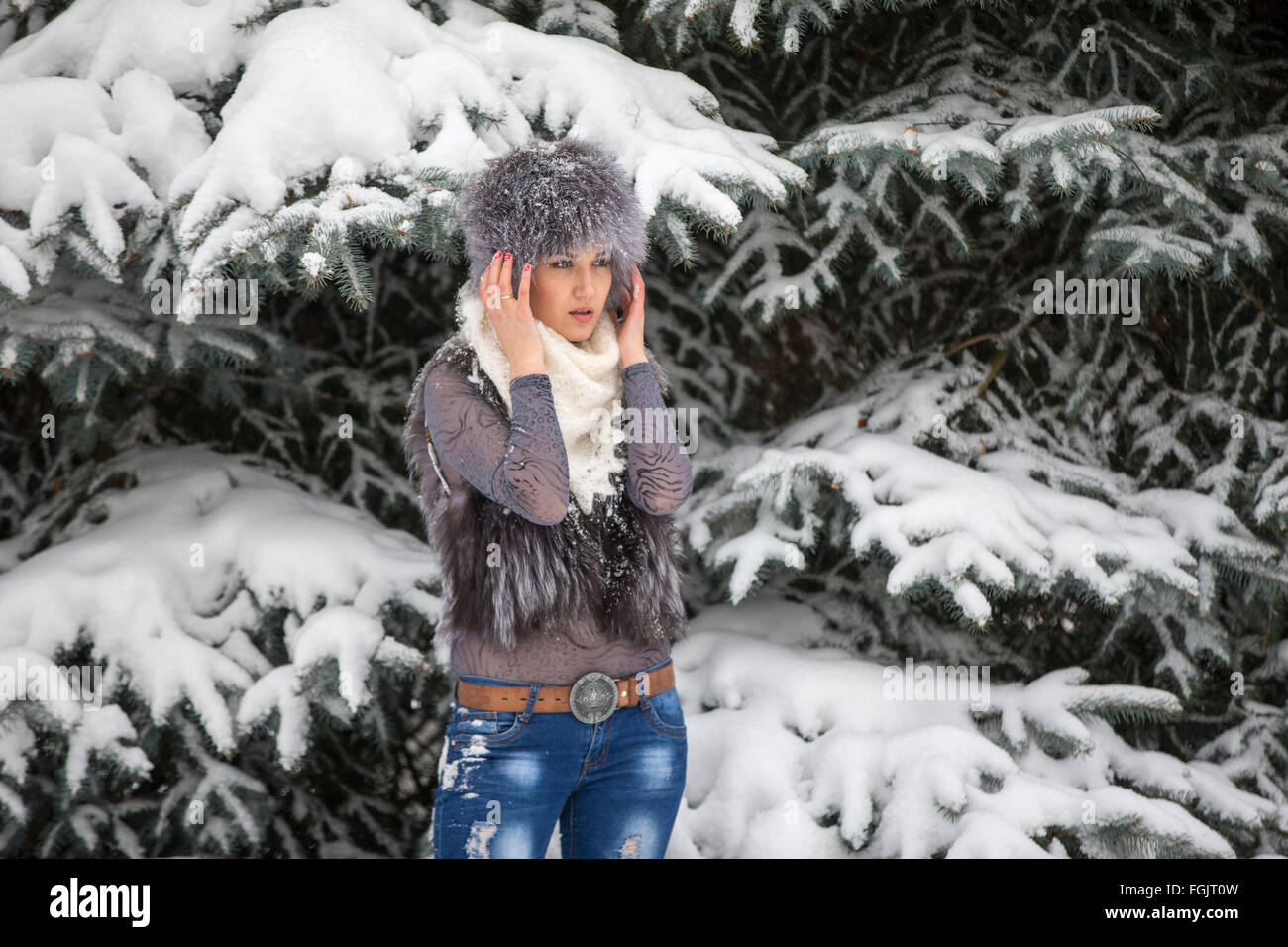 Die Frau in einem eleganten Schal gegen das Holz und Schnee im Winter Weihnachten Stockfoto