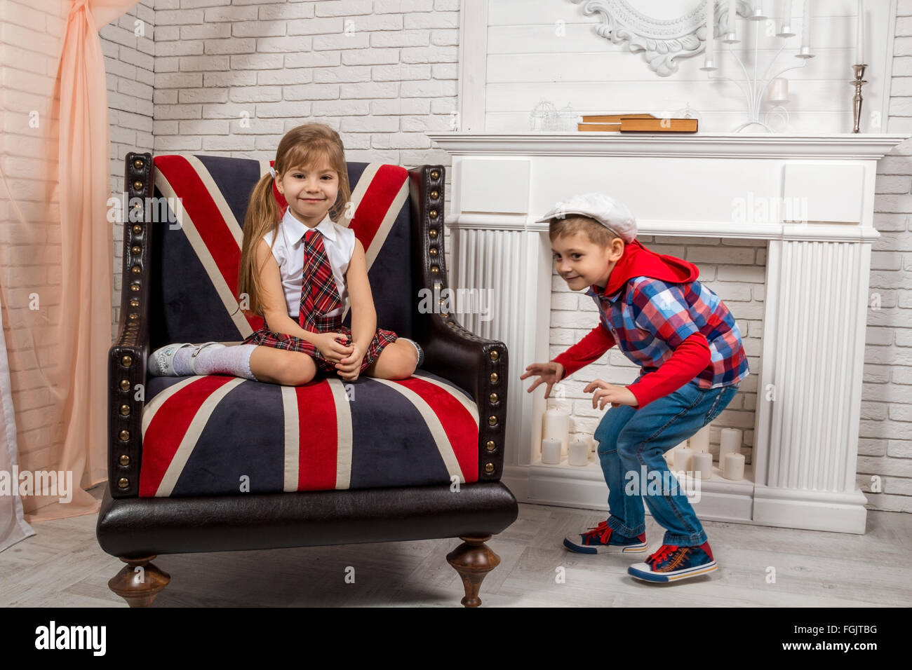 Mädchen sitzen auf einem Stuhl mit britischer Flagge Stockfoto