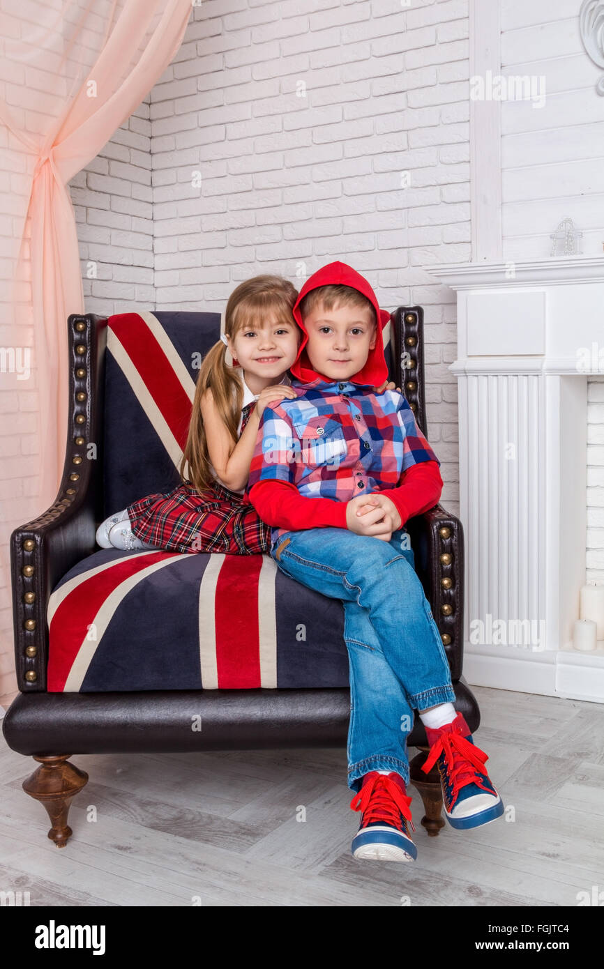 Mädchen und Jungen auf Stuhl sitzend mit britischer Flagge Stockfoto