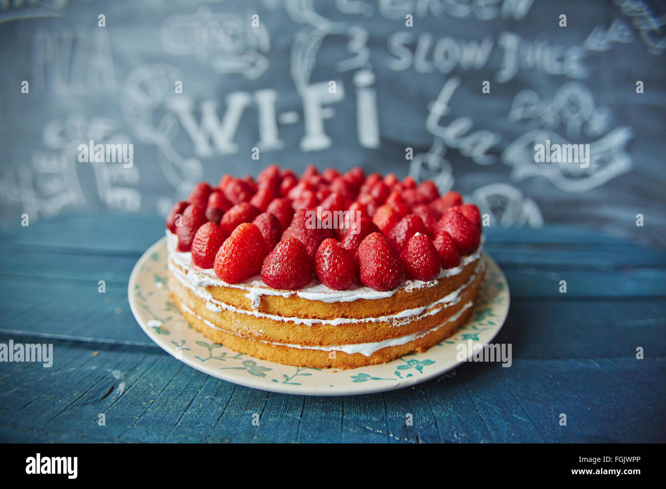 Leckere Kuchen mit frischen Erdbeeren und Buttercreme dekoriert Stockfoto