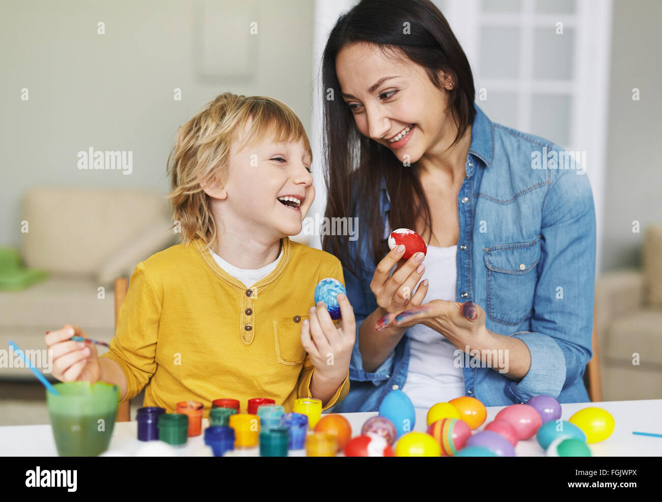 Junge Frau und kleine Junge bemalen von Ostereiern Stockfoto