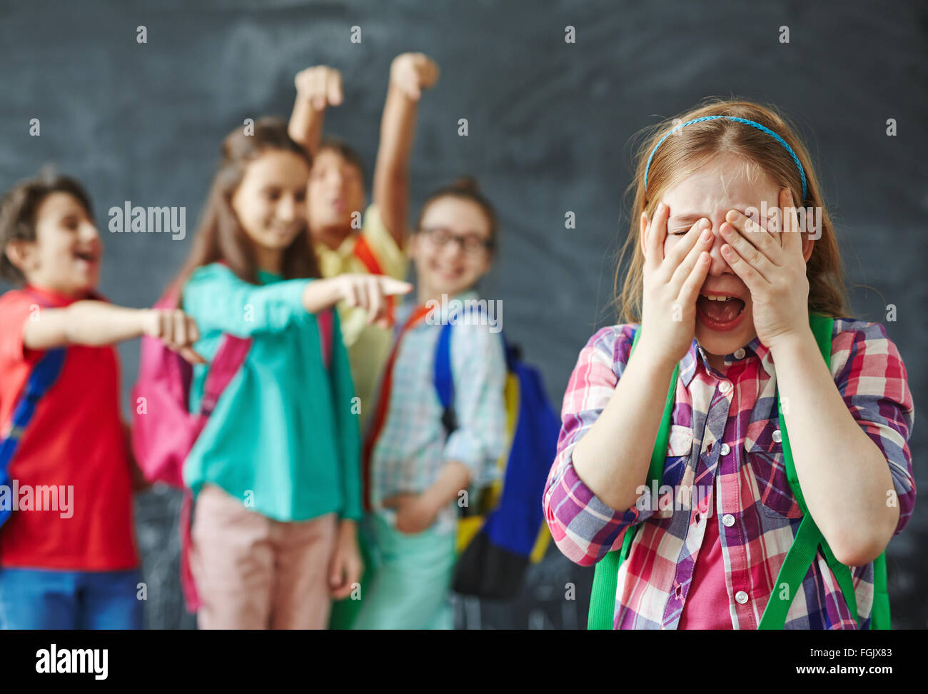 Schulmädchen auf Hintergrund der Hänselei Klassenkameraden Weinen Stockfoto