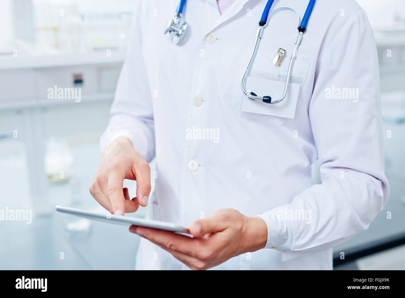Zeitgenössische Kliniker mit Touchpad Blick durch elektronische Daten Stockfoto