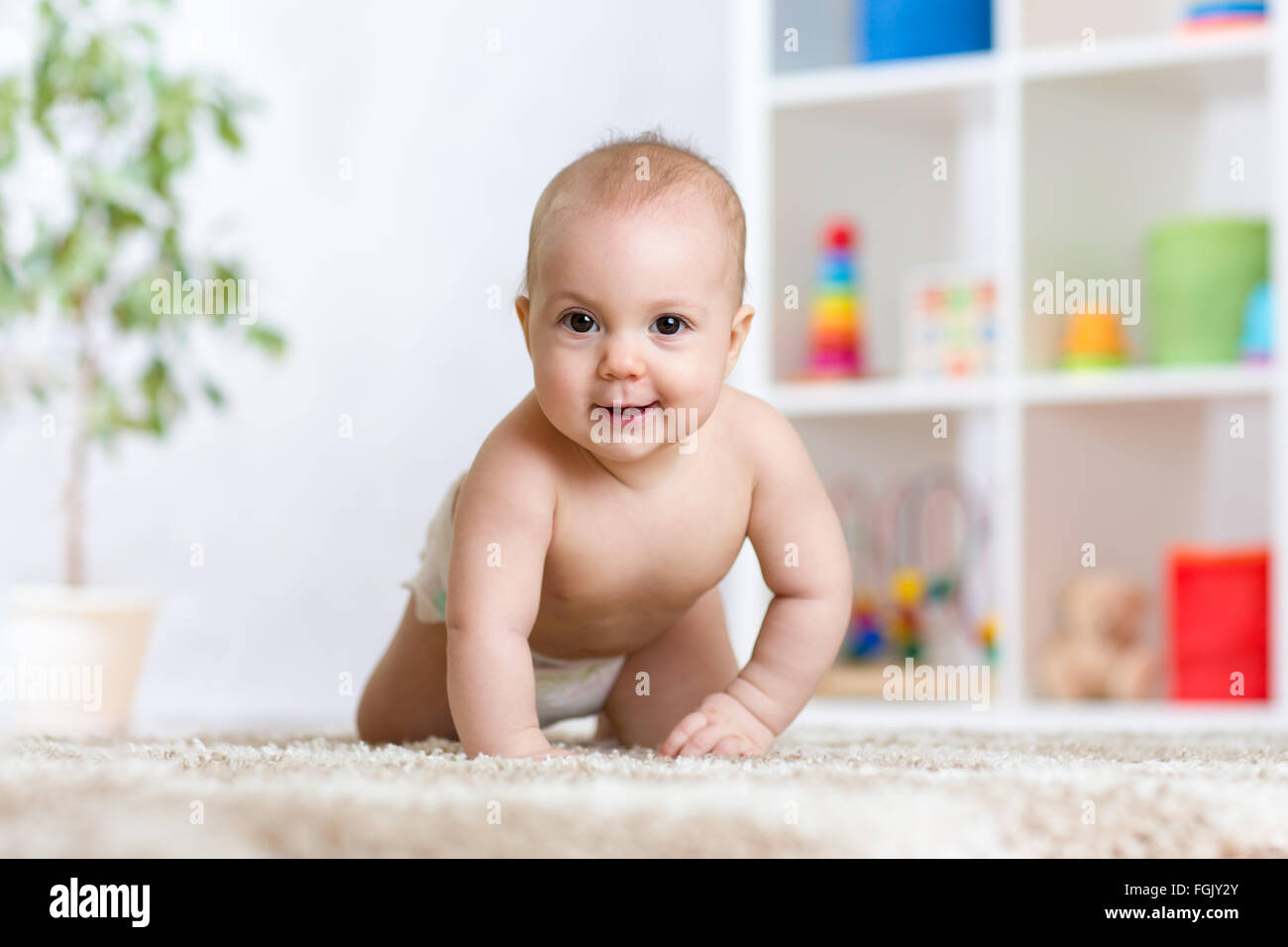 entzückende Baby krabbeln auf Teppich zu Hause Stockfoto