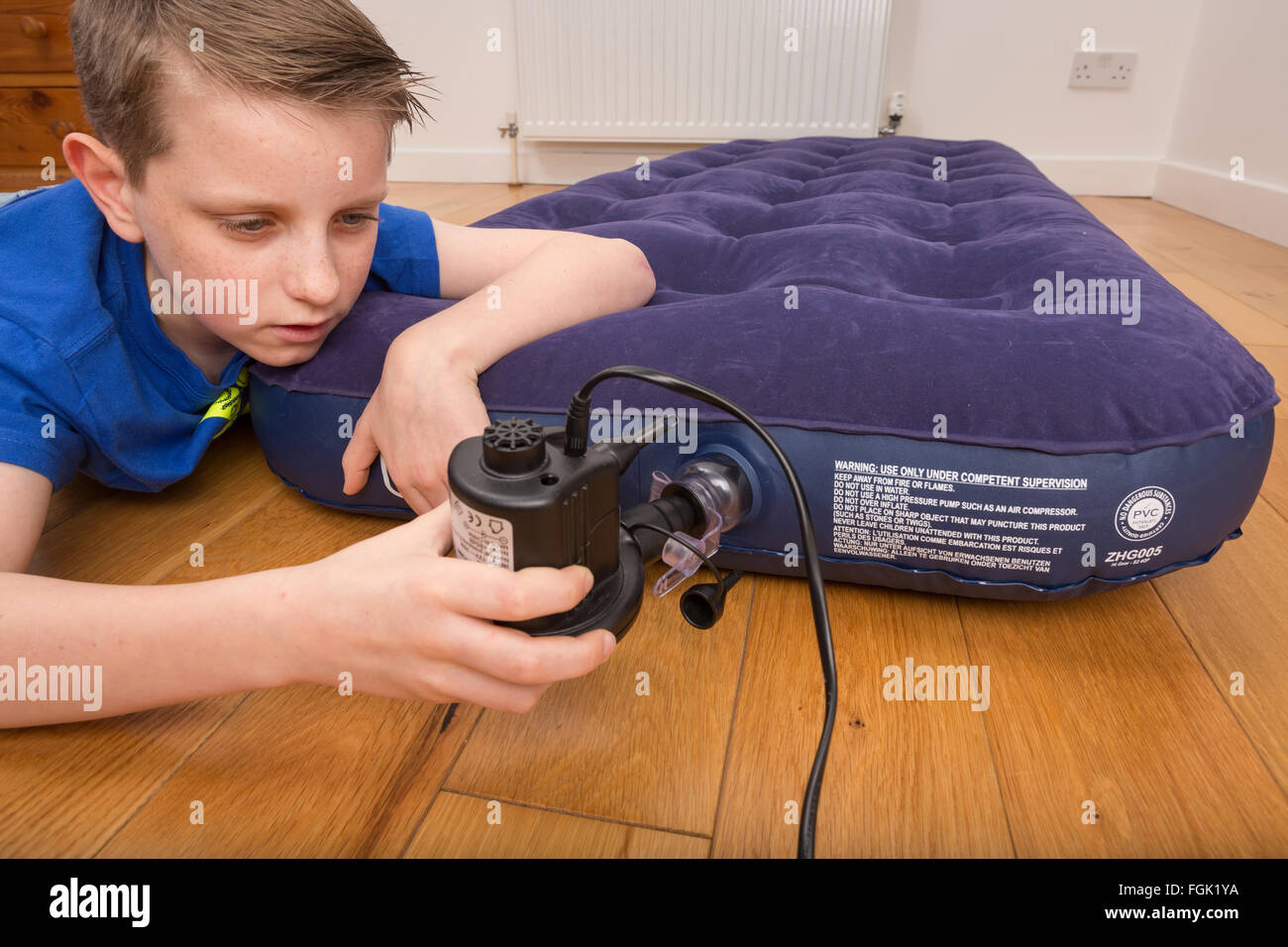 Ein Luftbett wird mit einer elektrischen Pumpe aufgeblasen Stockfoto