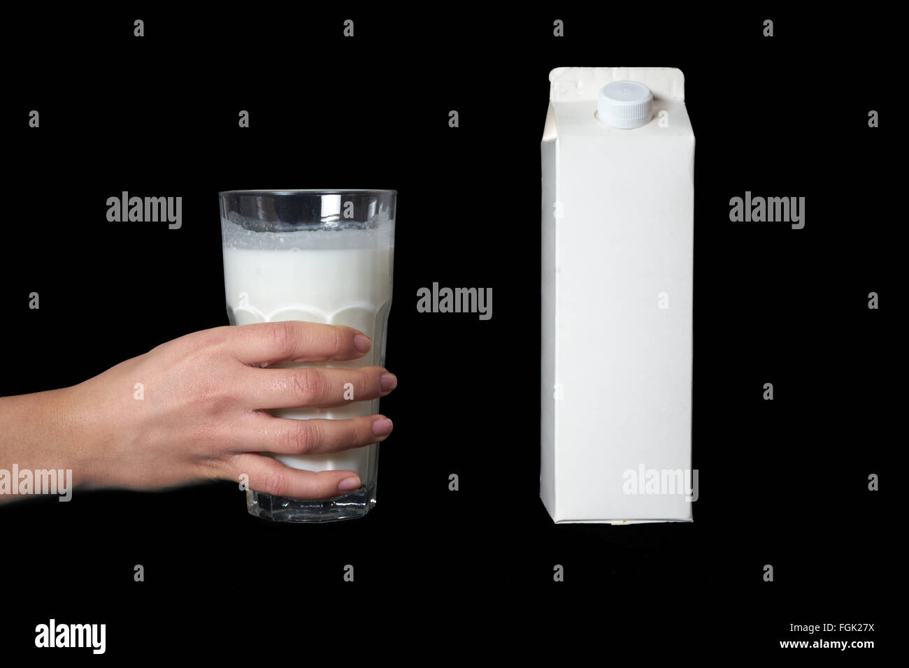 Hand mit Glas Milch auf schwarzem Hintergrund isoliert Stockfoto