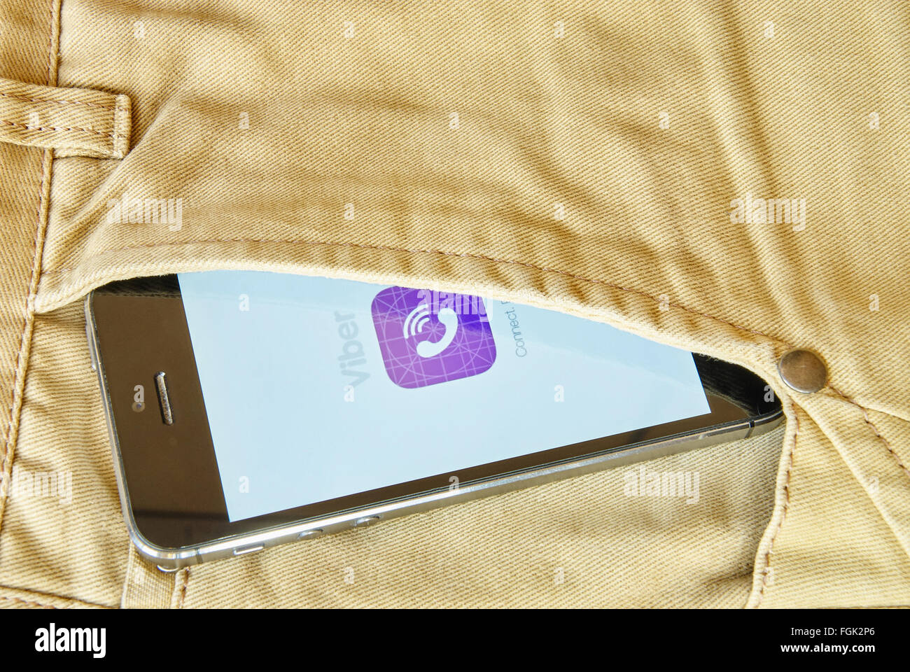KRIWOJ ROG, UKRAINE - 12. Dezember 2015: iPhone 5 s mit mobilen Anwendung für Viber auf dem Bildschirm in orange Jeans-Tasche Stockfoto