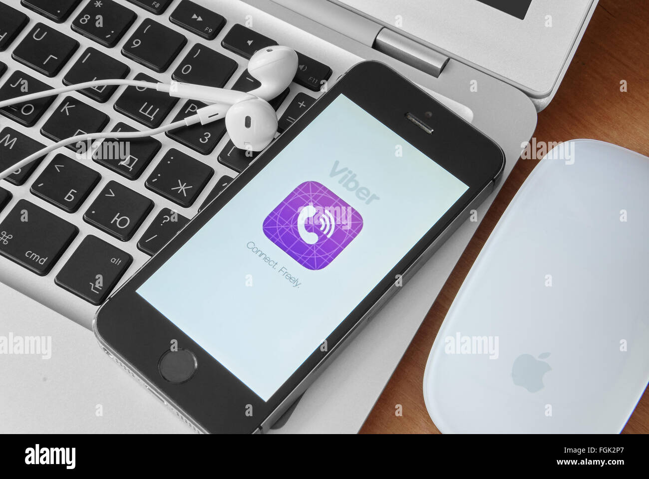 KRIWOJ ROG, UKRAINE - 12. Dezember 2015: Kopfhörer und iPhone 5 s mit mobilen Anwendung für Viber auf dem Bildschirm. Silber macboo Stockfoto