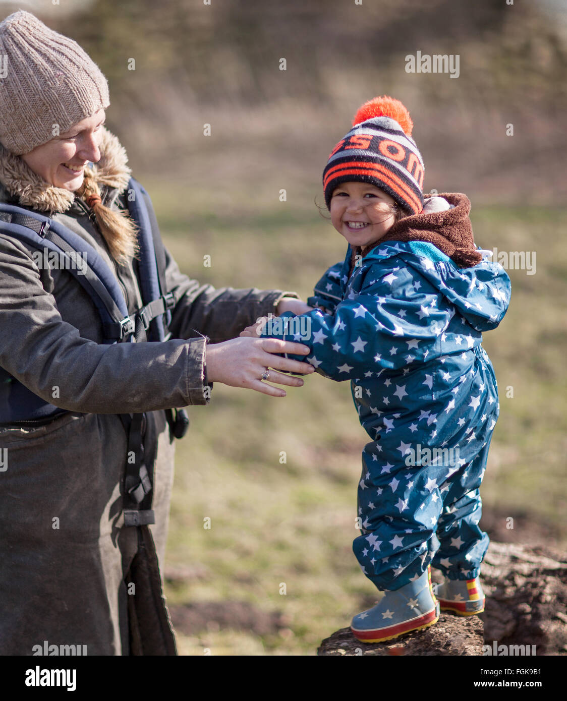 Mutter und drei Jahre alten Jungen Wintersonne draußen in der Natur zu genießen. Stockfoto