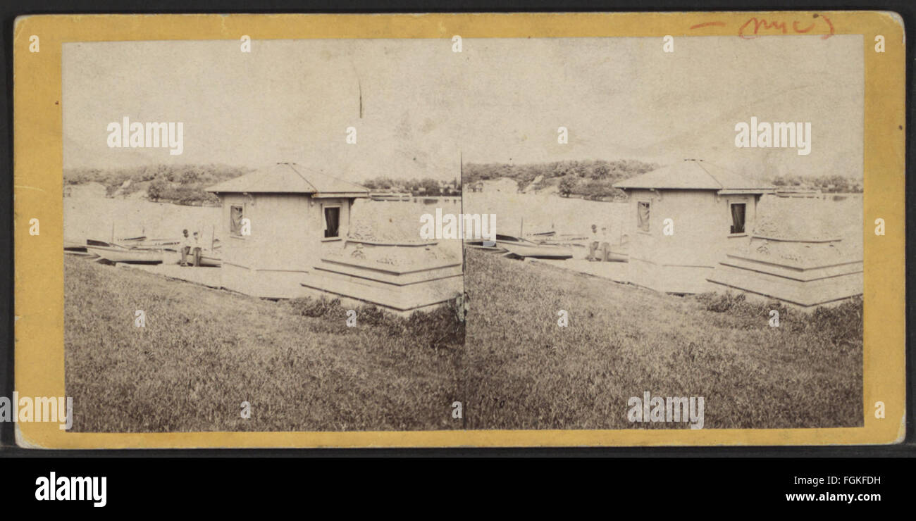 Foto von T. C. Roche, das ein provisorisches Bootshaus auf einem See am Fuße einer Terrasse zeigt. Das Bild erfasst die Struktur in ihrer Umgebung am See. Stockfoto