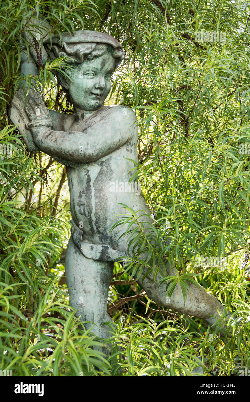 Denkmal des jungen Cherub wie junge unter grünen, grünen Laub Stockfoto