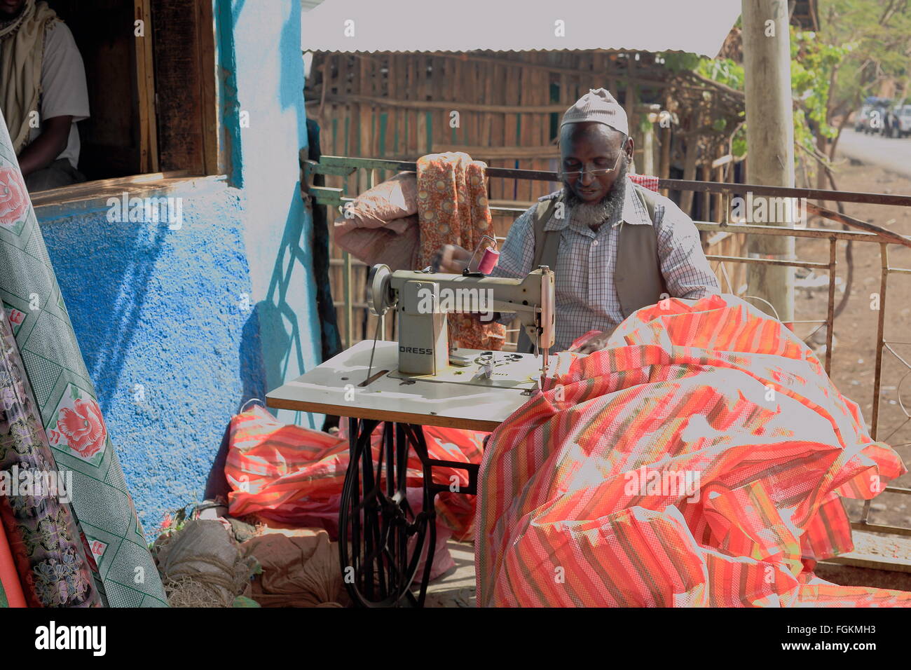 DEGAN, Äthiopien-März 25, 2013: Lokale Taylor arbeitet bei seinem Haus Veranda neben der Straße mit einer alten Nähmaschine. Stockfoto