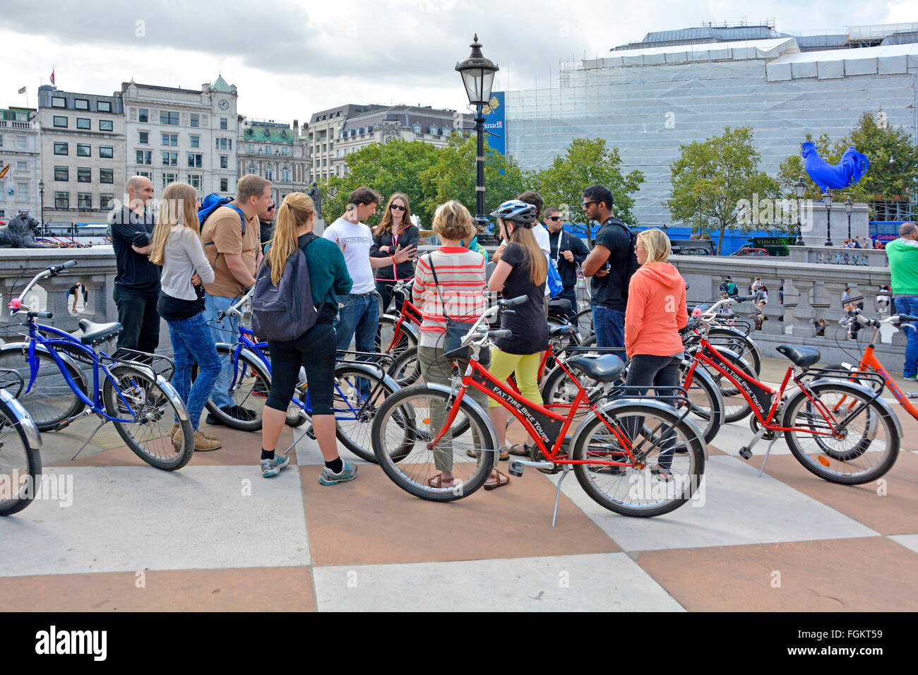 Tour Guide Führer im Gespräch mit einer Gruppe von Touristen Radfahren rund um London gesehen hier bei einem Stopp in Trafalgar Square England UK Stockfoto