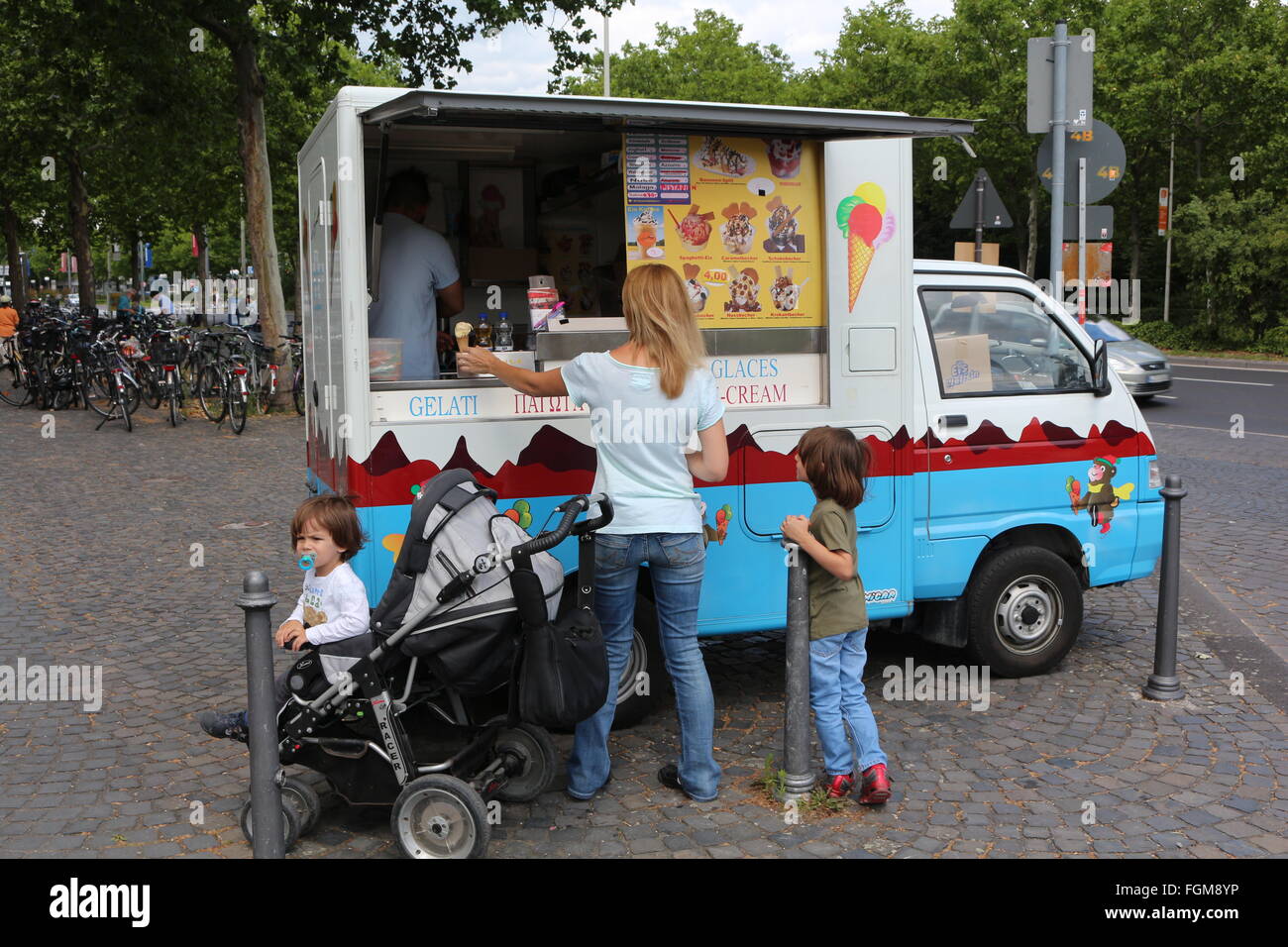 Mann verkaufte Eis zu einer Frau mit ihren Kindern Stockfoto