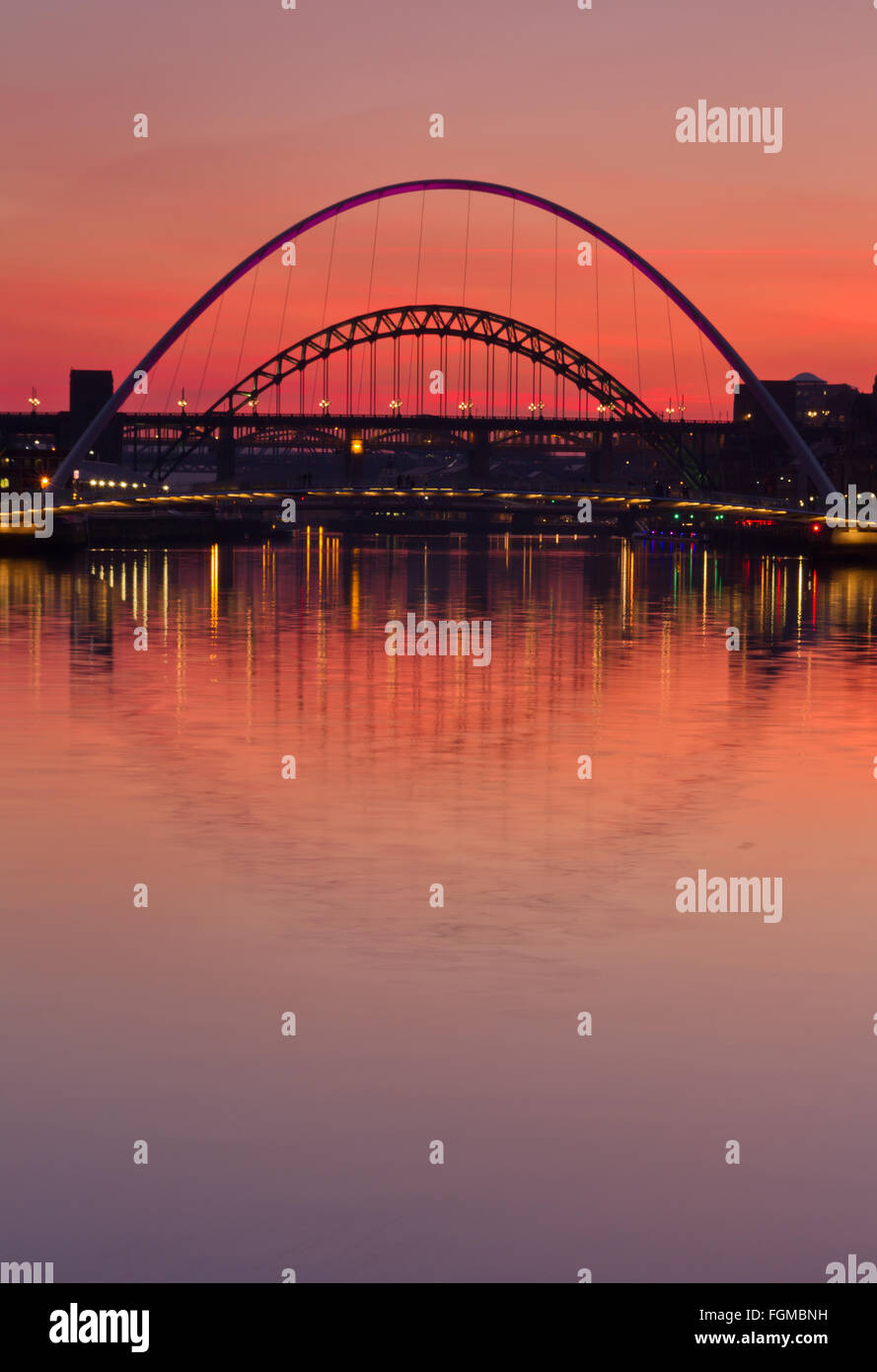 Millennium, hohe und Tyne Bridges spiegelt sich in den Fluss Tyne in der Dämmerung mit einem starken orange sunset Stockfoto