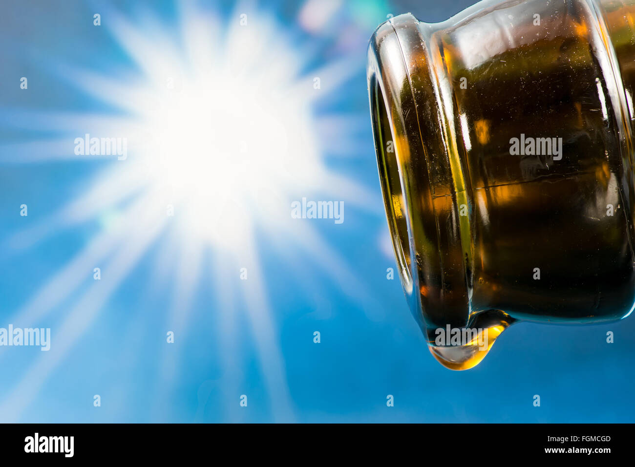 Letzten Tropfen eine leere Bierflasche mit der Sonne im Hintergrund Stockfoto