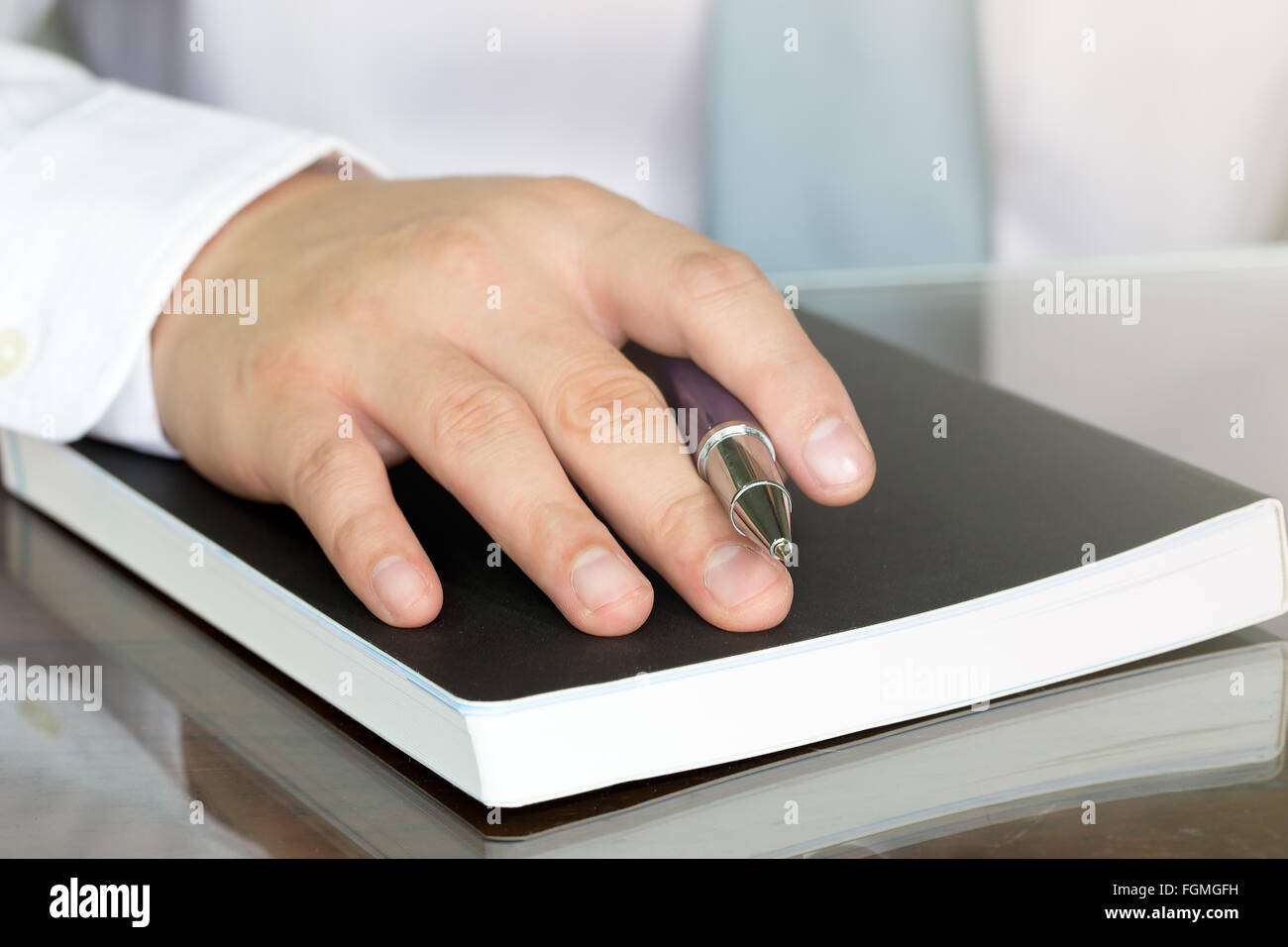 Geschäftsmann Hand mit Stift auf Notizbuch Stockfoto