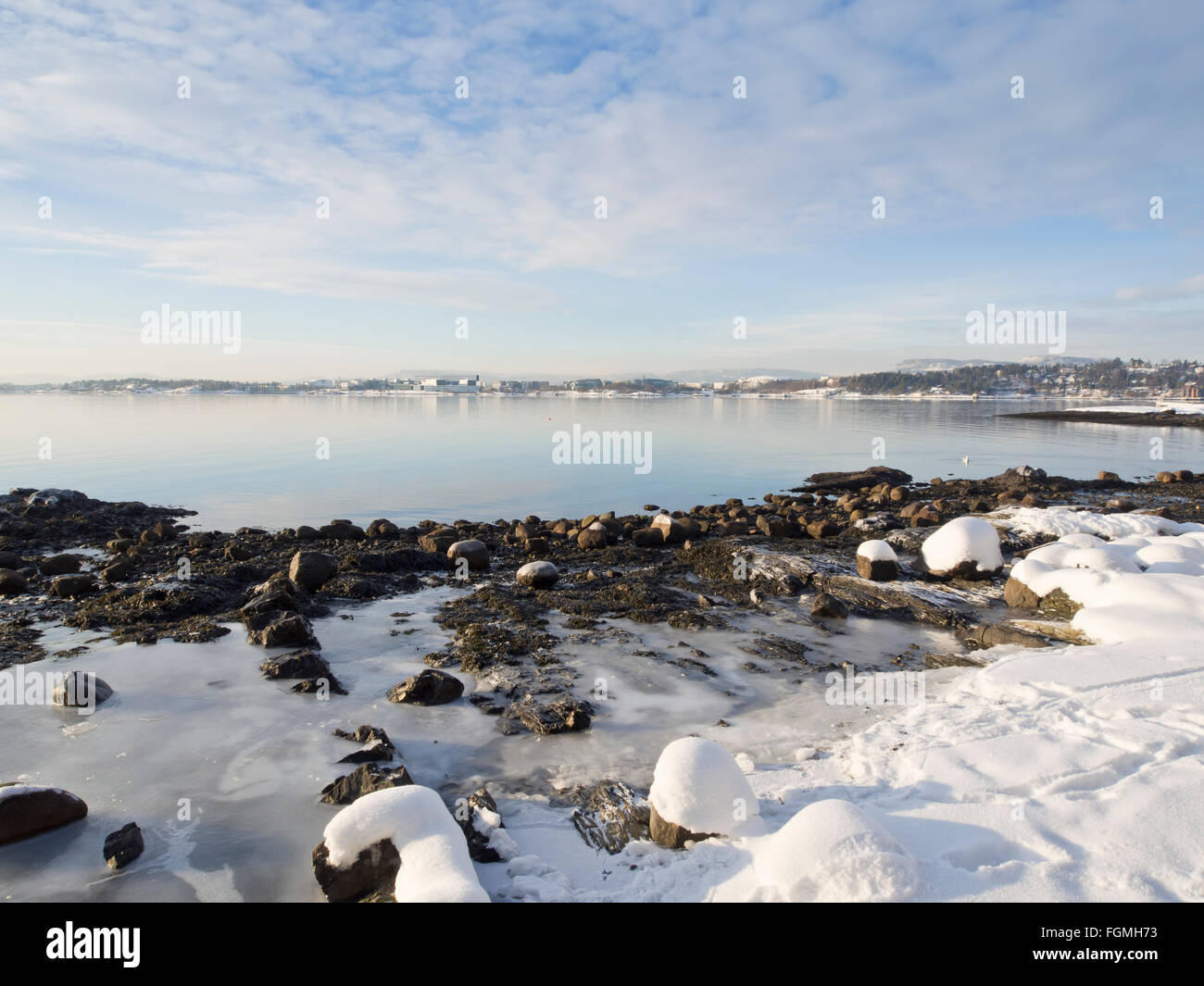 Ein Wintertag auf dem Oslofjord in Bygdøy Oslo Norwegen, tiefstehende Sonne, Schnee und Eis auf den Felsen, ruhiger Fußabdrücke See Stockfoto