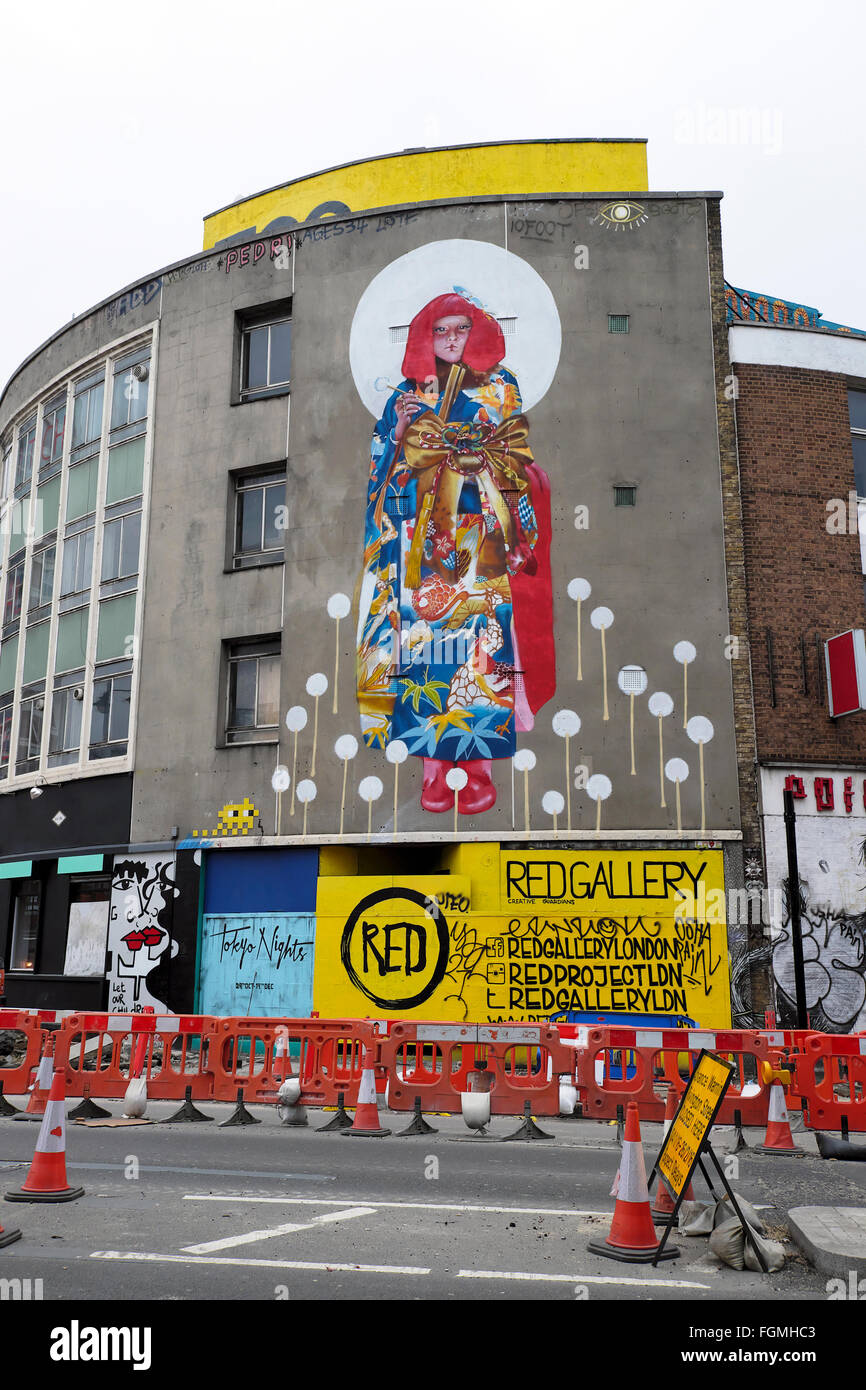 Baustellen und Japanerin Straßenkunst Wandbild in Shoreditch London England UK KATHY DEWITT Stockfoto